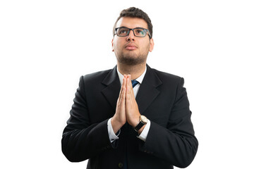 Faithful male entrepreneur looking up making praying gesture