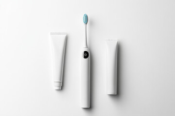Minimalist and visually appealing arrangement of an electric toothbrush and two tubes of toothpaste on a white background promotes oral hygiene
