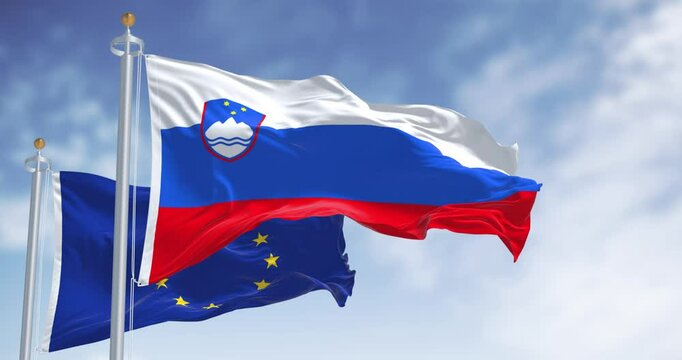 Slovenia and the EU flags waving on a clear day