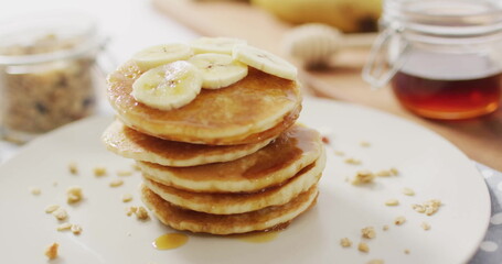 Image of pancakes on table with syrup and bananas