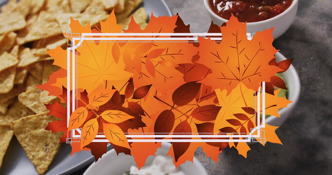Image of frame with fall leaves over nachos with dips