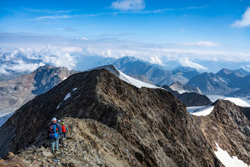 Climbers navigate the rocky terrain at the north summit of Wildspitze in Austria, surrounded by...