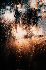 Abstract background of drops on glass in the evening city.