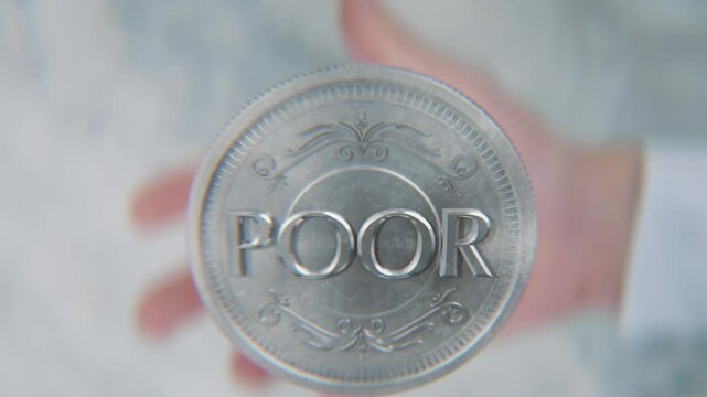 A hand flips a coin marked Rich and Poor, spinning toward the camera in slow motion