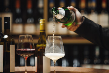 Unrecognizable Professional Sommelier Pouring Sparkling Wine in Wine Cellar
