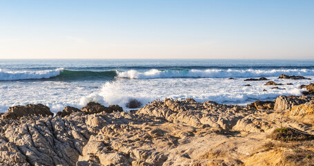 waves crashing along the rocky shoreline at Pacific Grove, California, USA in late afternoon in November