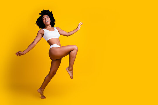 No filter studio photo of carefree slender woman underwear enjoying self acceptance blank space isolated yellow color background