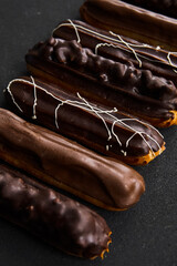 Chocolate tubes on a black background. Tubes with sweet filling in different colors. Sweets concept.Eclair with cream