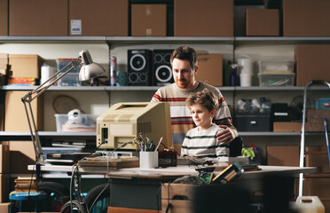 Father and son using an old computer together