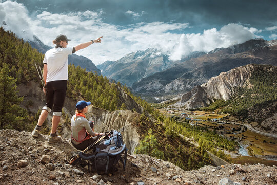 Happy couple hikers in mountains enjoying scenic on view of mountains during hike in Himalayas, Nepal.