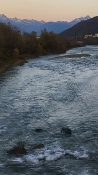 Moon rising over dora baltea river in aosta November