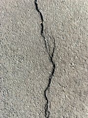 Cracked asphalt roads need to be repaired for the safety of pedestrians and motor vehicles.