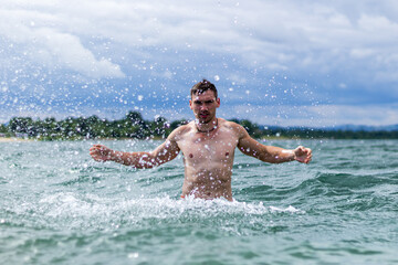 Junger sportlicher aktiver dynamischer Mann im Wasser beim Schwimmen und Fitness Training