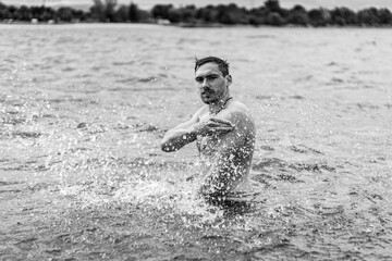 Junger sportlicher aktiver dynamischer Mann im Wasser beim Schwimmen und Fitness Training