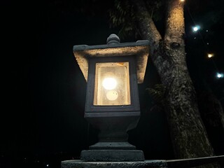 Stylish vintage lamp with a cubic structure and a protective concrete shade, ideal for garden decor