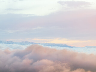 Drone view of  mountains at sunset. Beautiful pink clouds covered the earth. Evening landscape.