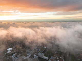 Drone view of the town and mountains at sunset. Beautiful clouds covered the city. Golden sunset....
