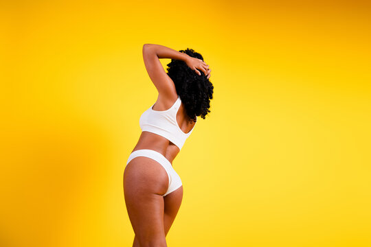 No filter studio photo of fit slender woman underwear enjoying self acceptance blank space isolated yellow color background