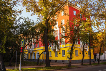 Naklejka premium Historic building with colorful facade surrounded by trees on a sunny day. Irkutsk city, historical building.