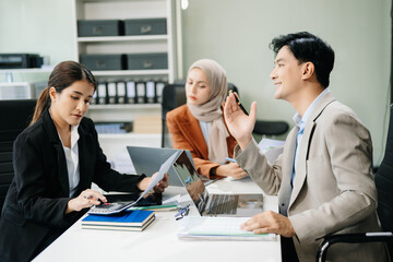 Fototapeta premium Asian businesspeople while collaborating on a new project. using a laptop and tablet