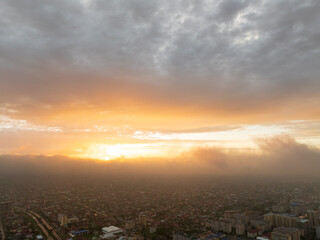Drone view of the town and mountains at sunset. Beautiful clouds covered the city. Golden sunset....