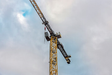 industrial crane machinery stands out against a cloudy sky