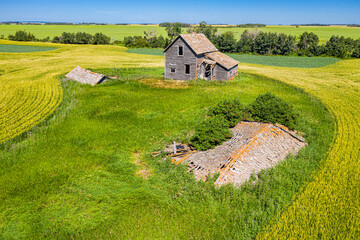 A small house is in the middle of a field