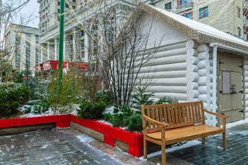 A white wooden house made of rounded logs and Christmas tree decorations on Christmas Eve. Festive...