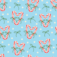 Cute red candy canes with bows, berries and holly plant berries seamless pattern on blue. Holiday season festive background. Elegant design for wrapping paper, fabric.