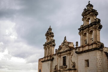 Historic stone church facade under a cloudy sky.