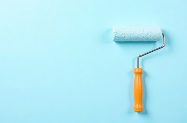 Obraz premium Paint roller on light blue wall for home renovation and interior design
