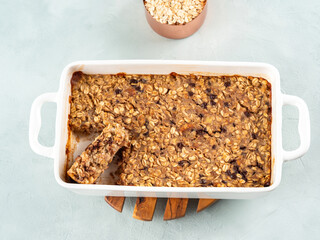 Vegan oatmeal banana cake in white baking pan on turquoise