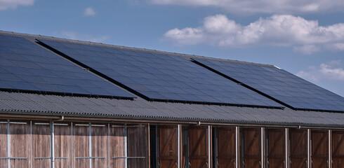 Large array of solar panels on a agracultural shed roof promoting residential green energy in the...