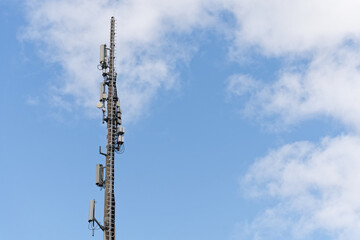 cell phone tower. blue sky in background. empty space