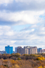 Obraz premium blue cloudy sky over buildings and colorful park