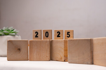 wooden scrabble labeled with numbers 2025 on the wooden cube block, new year concept