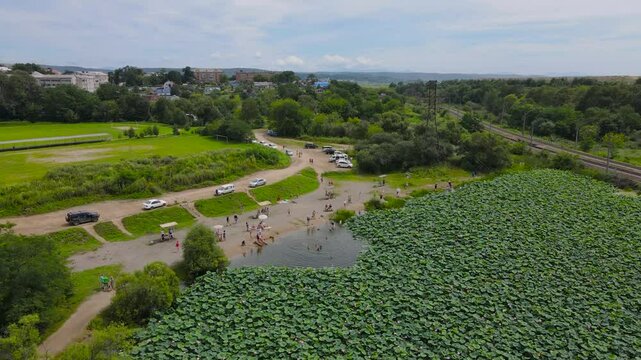 August 12, 2020 - Artem, Russia - View from above. Lake with lotuses. People are relaxing on the lake with blooming lotuses.