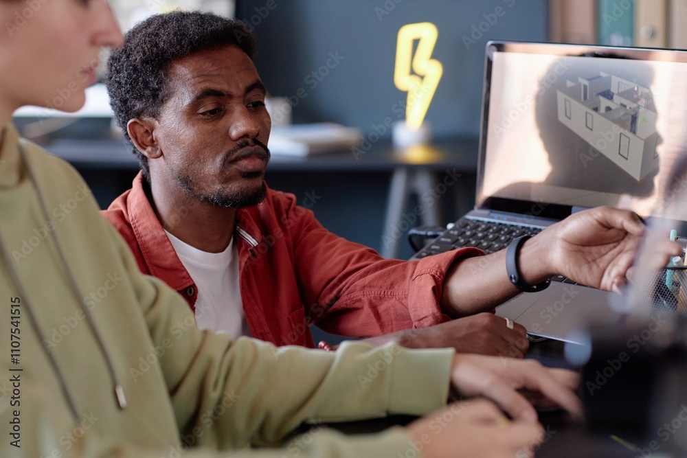 Fototapete black person and caucasian person collaborating on new architectural design using computer screen in