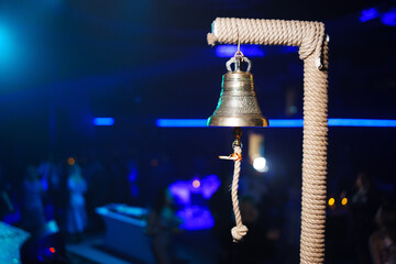 A large bell on the stage against the background of a dark concert hall. a themed sea party or performance.