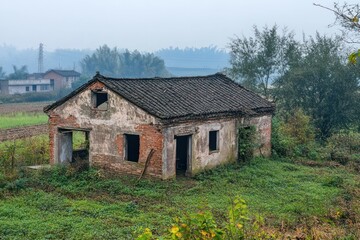 Obraz premium Rural abandoned buildings scattered across countryside landscapes, left untouched for decades