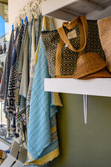 Shawl, scarves and textiles gift stall. Rows of soft coloured ladies hats and bags for sale. Tourist market.