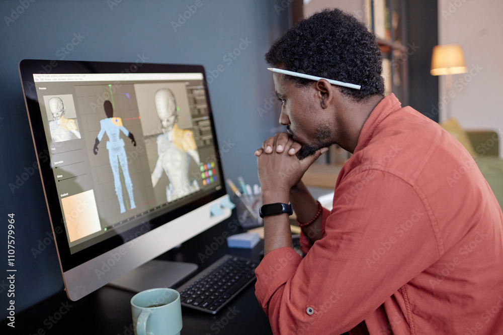 Leinwandbilder young man developing 3d character model on computer screen while working in modern office, wearing c
