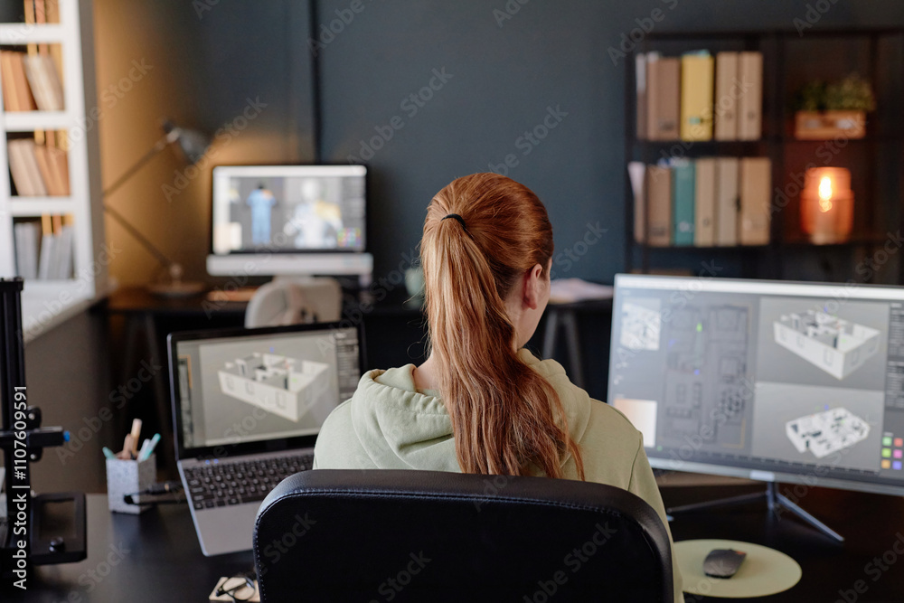 Poster person with long hair sitting in front of multiple monitors, designing architectural structures in a
