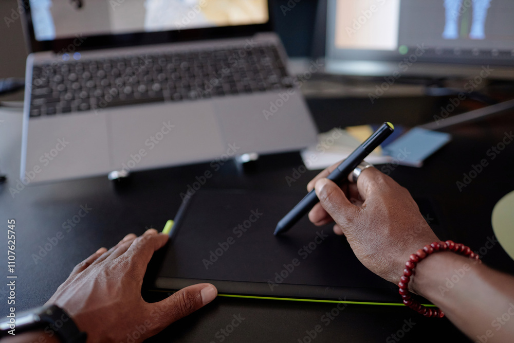 Leinwandbilder person holding stylus working on graphics tablet. digital artist creating design on tablet with lapt