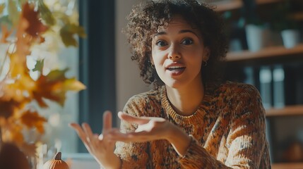 A confident female professional explaining a concept during a team meeting in a fall-themed office