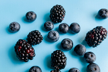  waffle ice cream cone cup with blackberries and blueberry on blue background