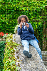 Latin American middle-aged tourist, smiling with a camera,