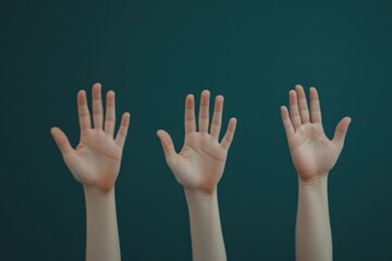 Obraz premium Three raised hands against a solid teal background, symbolizing participation, communication, or request for attention.