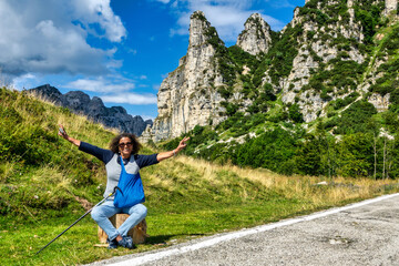 Latin American middle-aged tourist, smiling, with arms raised in joy,