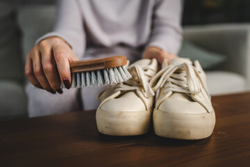 woman wash the sneakers with special brush tool, dirty shoes cleaning